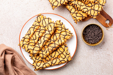 Top view of angel wings or sfrappole or chiacchiere decorated with chocolate  serpentine....