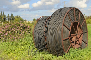 Cable drums with fiber optic cable.Technologies poly underground conduit in a green field, on a...