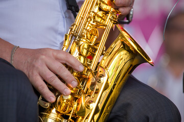 close-up of the hands of a  street musician playing the saxophone