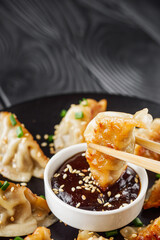 delicious fried gyoza dumplings on a black plate