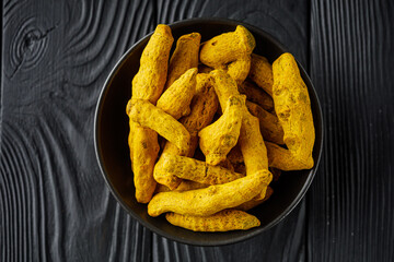 aromatic turmeric root on a black wooden rustic background