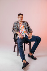 Back in time 90s 80s lifestyle concept. Studio footage of stylish cheerful young man in vintage retro jacket on light pink background, candy-colored fashions, creativity, emotions, facial expression