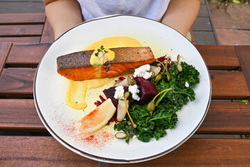Woman hold the healthy crispy salmon with kale. Healthy eating lifestyle habit. Self love, self care for physical, mindfulness eating. Concept. Healthy nutrition, diet good nutrition.