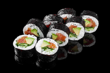 futomaki sushi roll with cucumber salmon avocado on a black mirror background