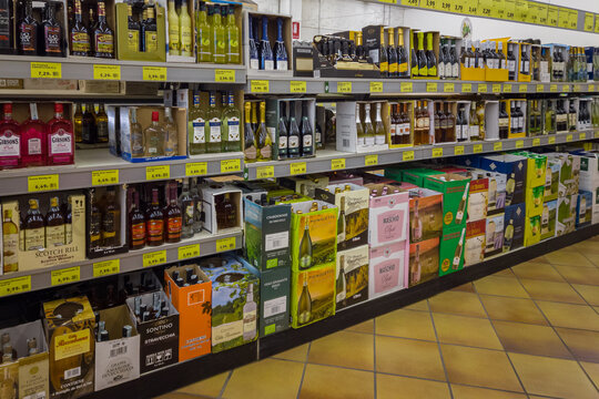 Italy - January 28, 2023: bottles of wine and spirits in cardboard boxes for sale on Italian supermarket discout store shelves