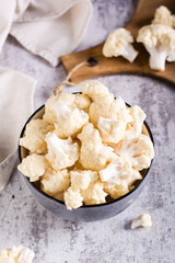 Fresh raw cauliflower in a bowl on the table. Natural antioxidant. Vertical view
