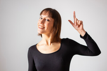 Portrait of a girl on white background. Brown short hair girl. Happy girl, raising her hand making a snap as if she had an idea