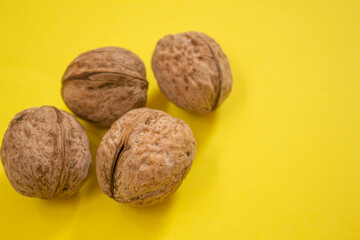 Top view of dried walnuts on yellow background with copy space