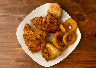 three pieces of fried chicken, onion rings and a biscuit