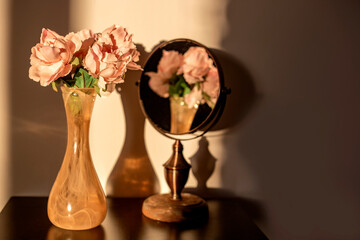 bouquet of roses in the vase in front of the mirror, young old beauty concept 