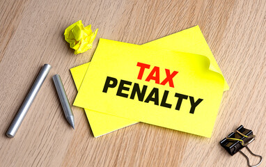 TAX PENALTY written on a sticky on notebooks