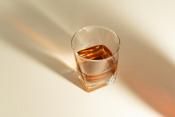 Still life with a glass of bourbon with lights on surface