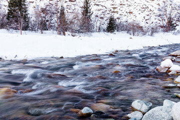 Flowing mountain river in winter