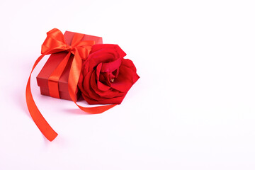 Happy Valentine's Day, Mother's Day and birthday greeting card. Red rose and gift box with a satin ribbon bow