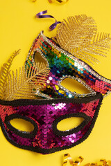 Festive face mask for carnival celebration or masquerade on colored background