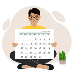 A man sits cross-legged and holds a large calendar glider in his hands. Concept of planning, make plans, schedule, event.