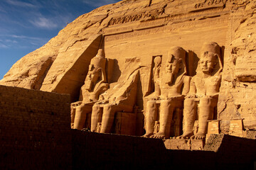 The facade of the Temple of Ramses II in Abu Simbel at sunset - obrazy, fototapety, plakaty