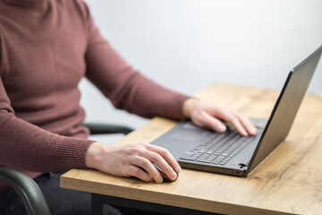 Fototapeta premium Close up of a man working on laptop at the office. Office worker hands typing on keyboard. Business man using laptop 