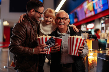 Grandfather son and granddaughter in movie theater.