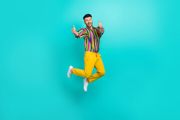 Full body photo of young jumping student man wear freak retro stylish outfit showing thumbs up recommend isolated on aquamarine color background
