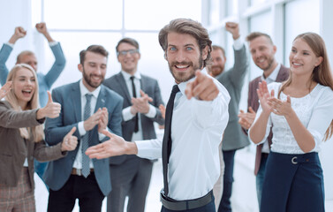 happy young business man pointing at you.