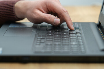 Close up of a man working on laptop at the office. Office worker hands typing on keyboard. Business man using laptop 