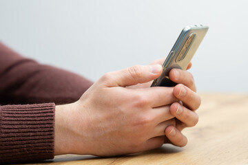 Fototapeta premium Man hands holding smartphone. Man using smartphone and pointing on the screen with one finger