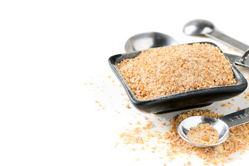 Whole Wheat Flour in black bowl and measuring spoon isolated on white