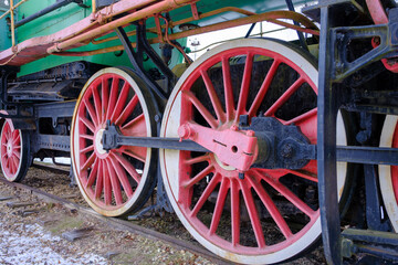 Old steam locomotive wheel and connecting rods. Tie rod or side rod for drive wheels. A retro specimen