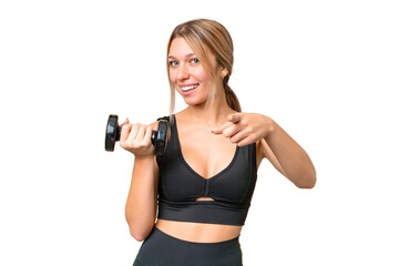 Blonde sport woman making weightlifting over isolated chroma key background points finger at you with a confident expression