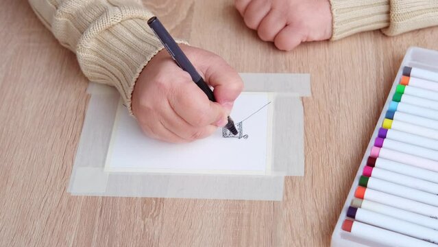 female artist's hand draws with colored paints house, trees, background, abstract spots spread on paper, watercolor painting, art therapy drawing for relaxation, mental health supportive care
