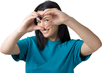 Portrait of a smiling young woman showing heart gesture with her fingers isolated over grey background