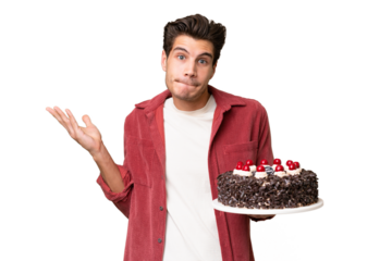 Young caucasian man holding birthday cake over isolated background having doubts while raising hands