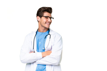 Fototapeta premium Young doctor man over isolated background with arms crossed and happy