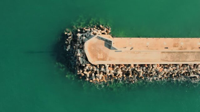 Aerial shot, drone point of view breakwaters surrounded by green waters of Mediterranean Sea of Santa Ponsa, small town in the southwest of Mallorca. Baleares, Spain
