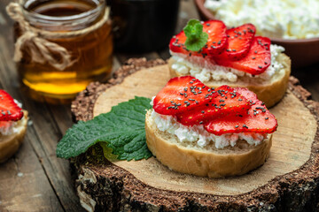 Crostini or toasts with strawberries and cream cheese ricotta. Delicious breakfast or snack, Clean eating, dieting, vegan food concept. top view