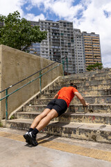 Brazil, Sao Paulo, Man doing push-ups on steps in city
