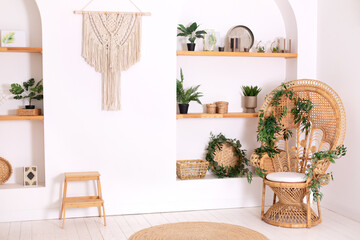 Rattan peacock armchair by the white wall in the living room. Wabi sabi room interior. Eco natural...