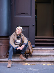 Fototapeta na wymiar Portrait of man sitting on steps in front of building