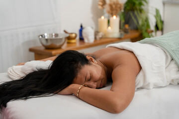 Obraz na płótnie Canvas Woman lying on massage table at spa