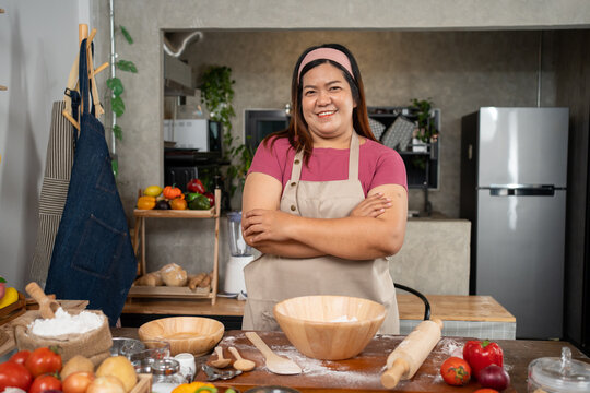 Portrait Of Obese Woman Cooking Pizza In The Kitchen, Raw Pizza In The Hands Of A Housewife. Homemade Pizza Cooking In The Kitchen At Home. Learning How To Make Yummy Pizza Dinner Lunch