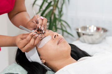 Close-up of woman having eyelash extension at spa - obrazy, fototapety, plakaty