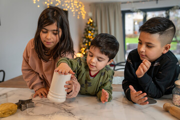 Fototapeta premium Kids preparing Christmas cookies in kitchen