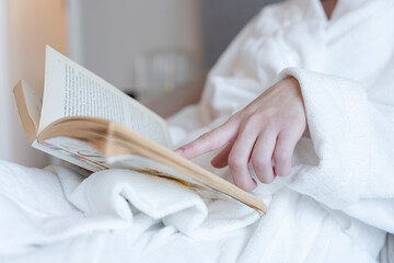Obraz na płótnie Canvas Close-up of woman in bathrobe reading book