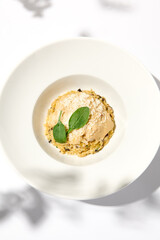 Italian food - mushrooms risotto with creamy espuma on light background. Mushroom risotto with cheese in summer menu Italian risotto with hard shadows from tree leaves. Trendy menu concept