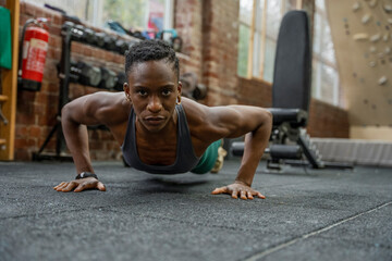 Obraz na płótnie Canvas Athletic woman doing push-ups at gym