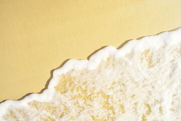 Close-up of a beach with a calm transparent wave. Romantic sea coast with golden sand.