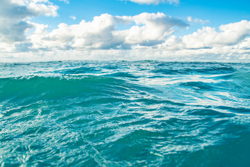 Fototapeta na wymiar Panorama of a calm sea with clouds on the horizon. Background on the theme of summer vacation and ecology. Crystal clear ocean water.