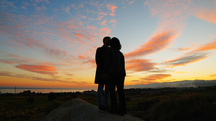 Silhouette of couple hug against the sunset sky