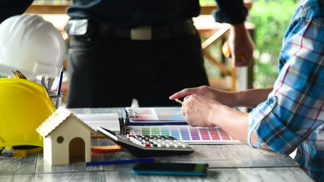 Contractor construction engineer meeting talking together on architect table at construction office site. Businessman engineer manager discuss with foreman team builder look at plan blueprint laptop